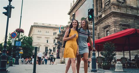 Külföldi turisták mosolyogva nézegetnek egy kézműves standot