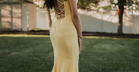 Nő elegáns ruhában, napernyővel, szabadtéri rendezvényen