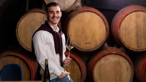 Fiatal borász dolgozik a pincében hordók között