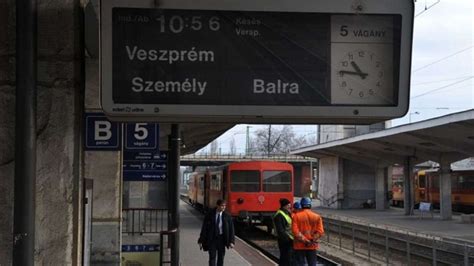 Gyermekek vonatokat néznek egy vasútállomáson